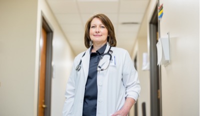 female nurse poses in hospital hallway